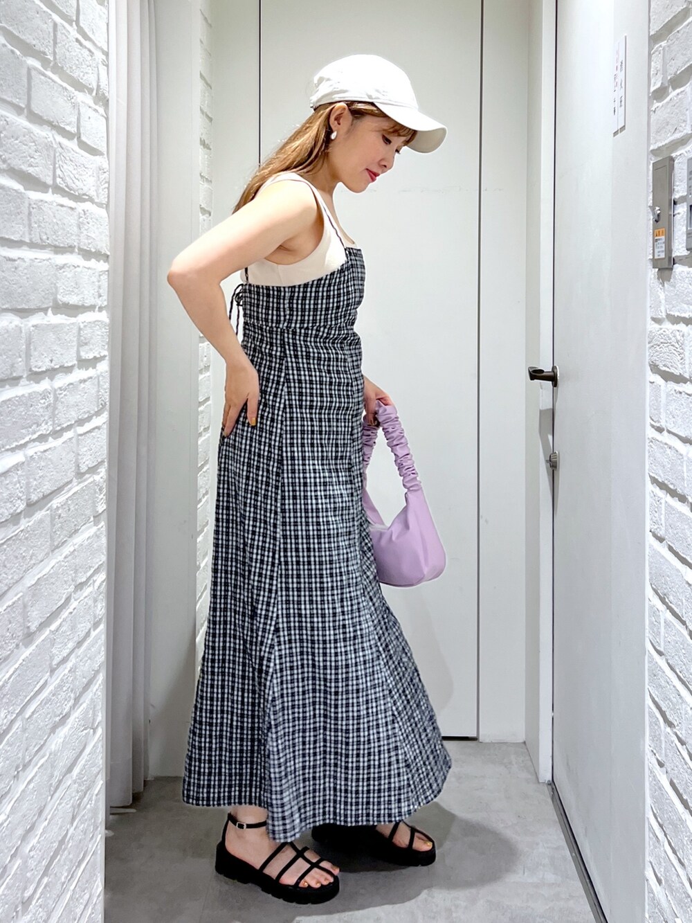 パープル系のハンドバッグ、ブラック系のサンダル、ホワイト系のカーディガン/ボレロを着用したレディースの夏コーディネートの6枚目の写真