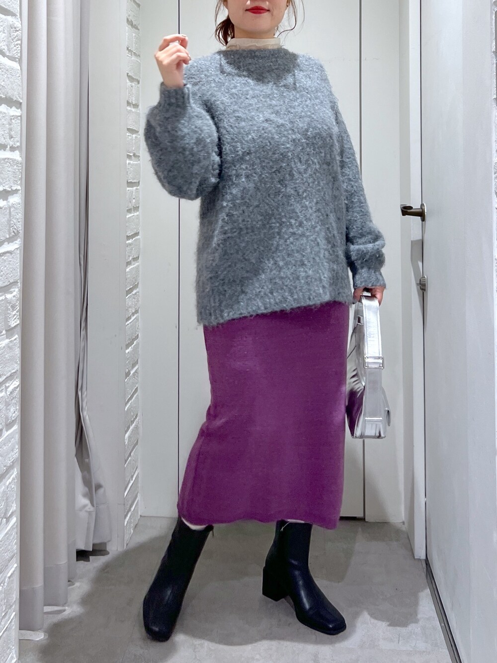 パープル系のスカート、グレー系のニット/セーター、ブラック系のブーツを着用したレディースの冬コーディネートの4枚目の写真