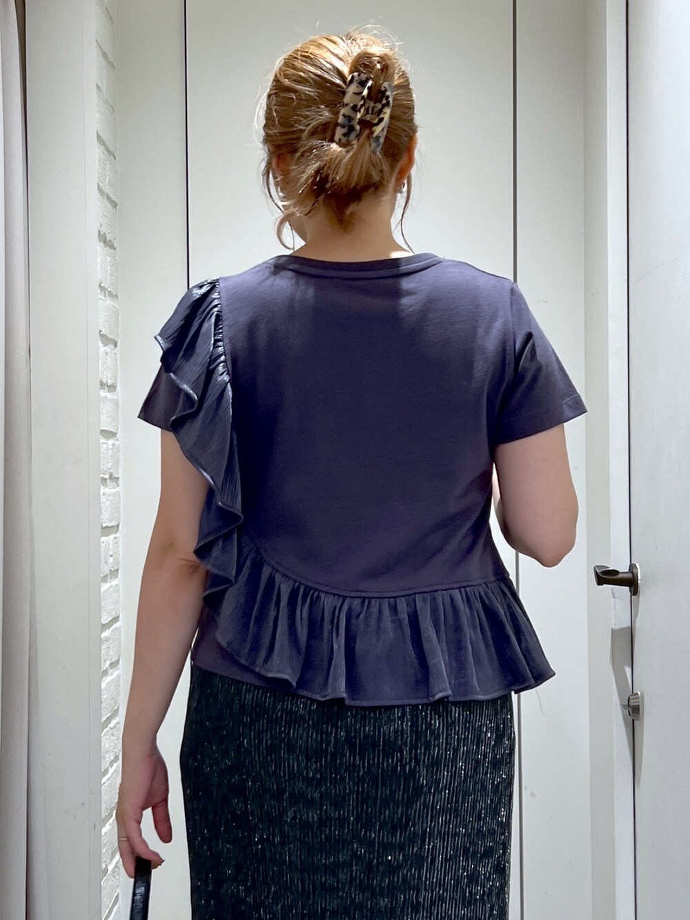 ブラック系のスカート、グレー系のTシャツ/カットソー、ブラック系のサンダルを着用したレディースの夏コーディネートの6枚目の写真