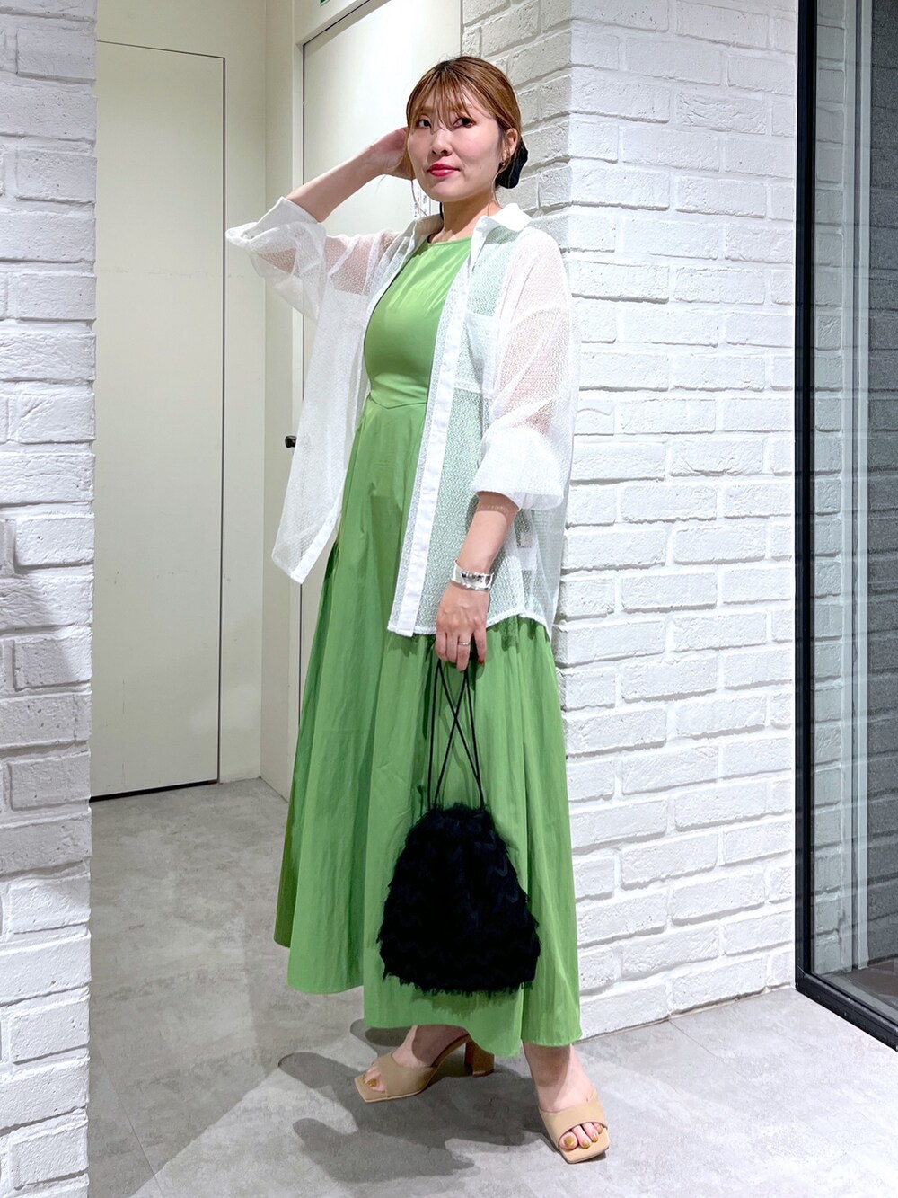 グリーン系のワンピース、ホワイト系のシャツ/ブラウス、ブラック系のハンドバッグを着用したレディースの夏コーディネートの5枚目の写真