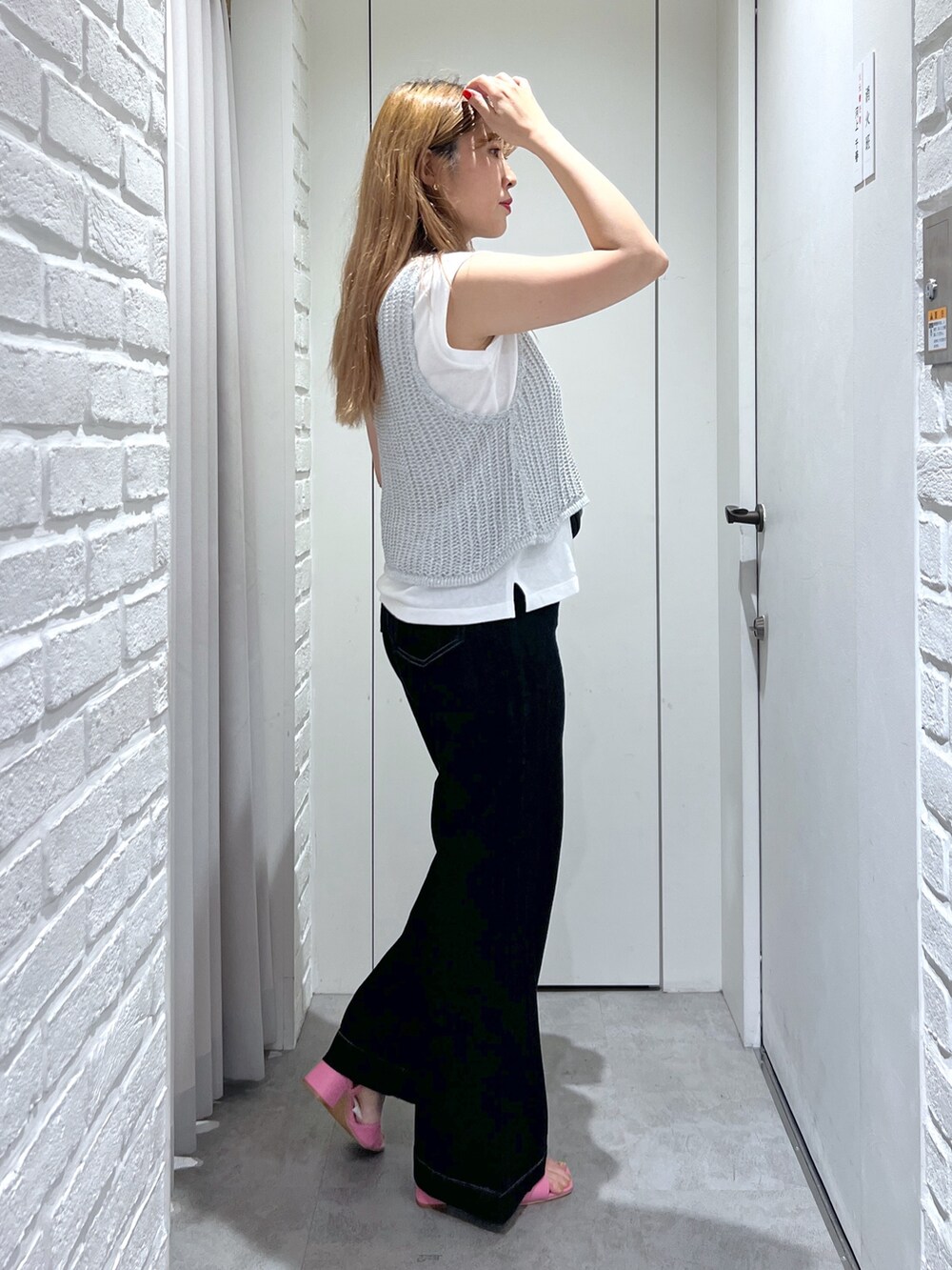 シルバー系のベスト、ブルー系のデニムパンツ、ピンク系のサンダルを着用したレディースの夏コーディネートの3枚目の写真