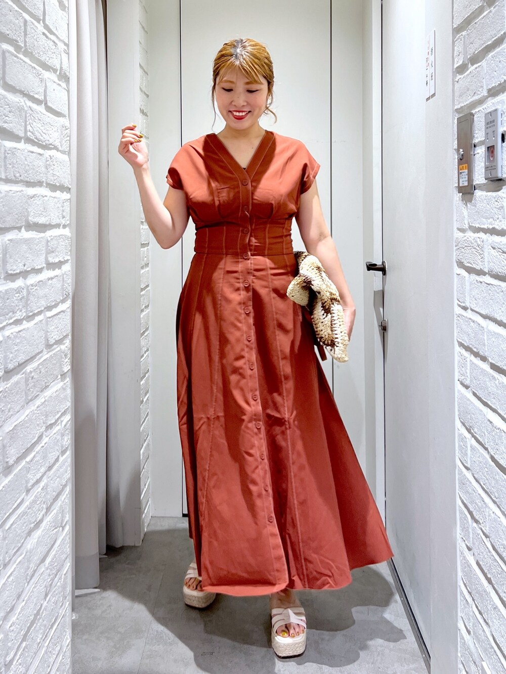 ブラウン系のワンピース、ベージュ系のトートバッグ、ホワイト系のサンダルを着用したレディースの夏コーディネートの2枚目の写真