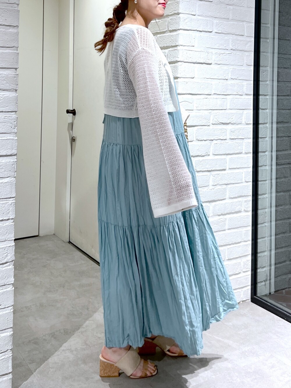 ホワイト系のカーディガン/ボレロ、グリーン系のワンピース、グレー系のサンダルを着用したレディースの夏コーディネートの6枚目の写真