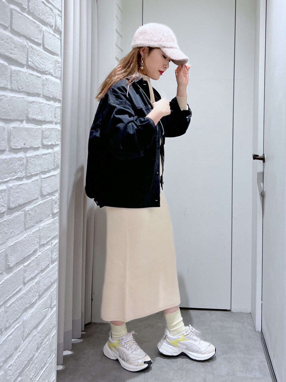 ホワイト系のワンピース、シルバー系のショルダーバッグ、ブラック系のデニムジャケットを着用したレディースの冬コーディネートの3枚目の写真