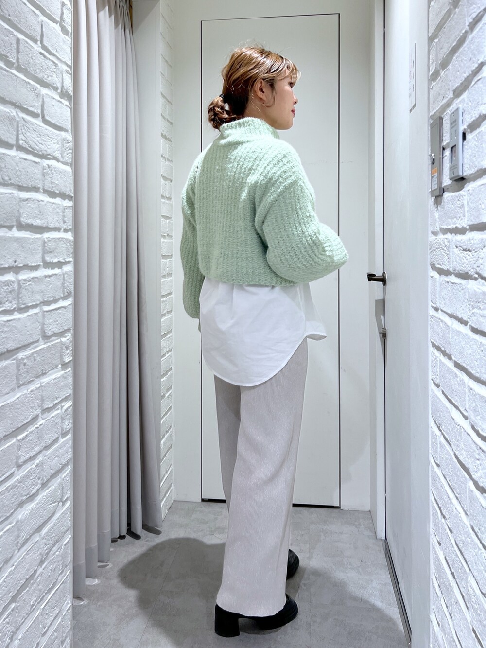 ホワイト系のシャツ/ブラウス、ホワイト系のその他パンツ、グリーン系のニット/セーターを着用したレディースの冬コーディネートの2枚目の写真