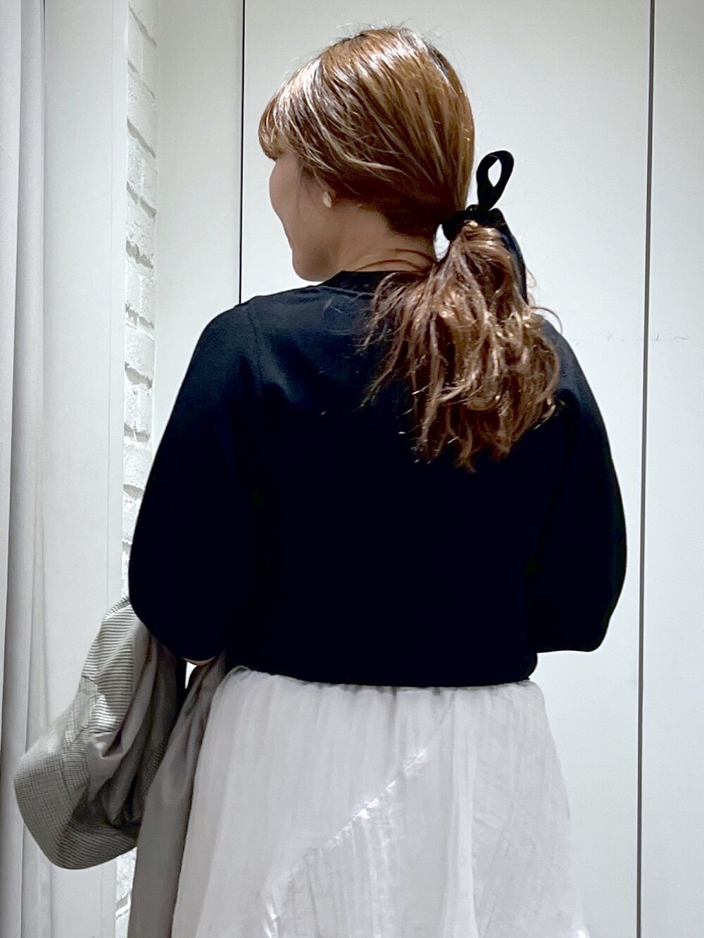 ブラウン系のテーラードジャケット、ホワイト系のスカート、ブラック系のパンプスを着用したレディースの春コーディネートの8枚目の写真