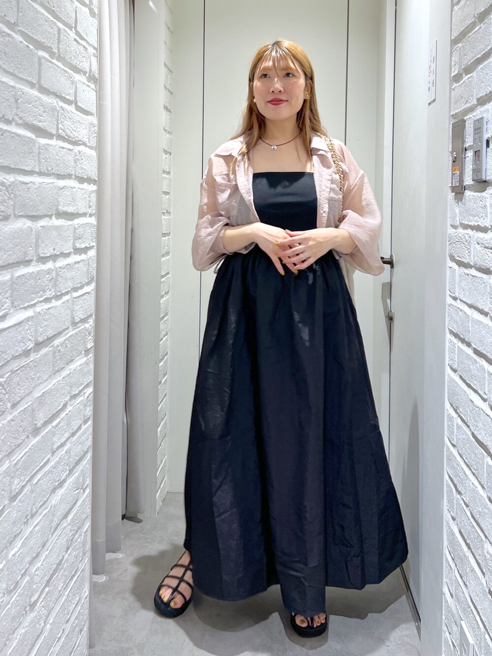 ブラック系のワンピース、ホワイト系のトートバッグ、ピンク系のシャツ/ブラウスを着用したレディースの夏コーディネートの2枚目の写真