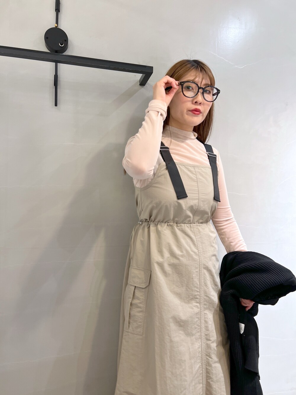 ベージュ系のワンピース、ブラック系のトートバッグ、ブラック系のカーディガン/ボレロを着用したレディースの冬コーディネートの5枚目の写真