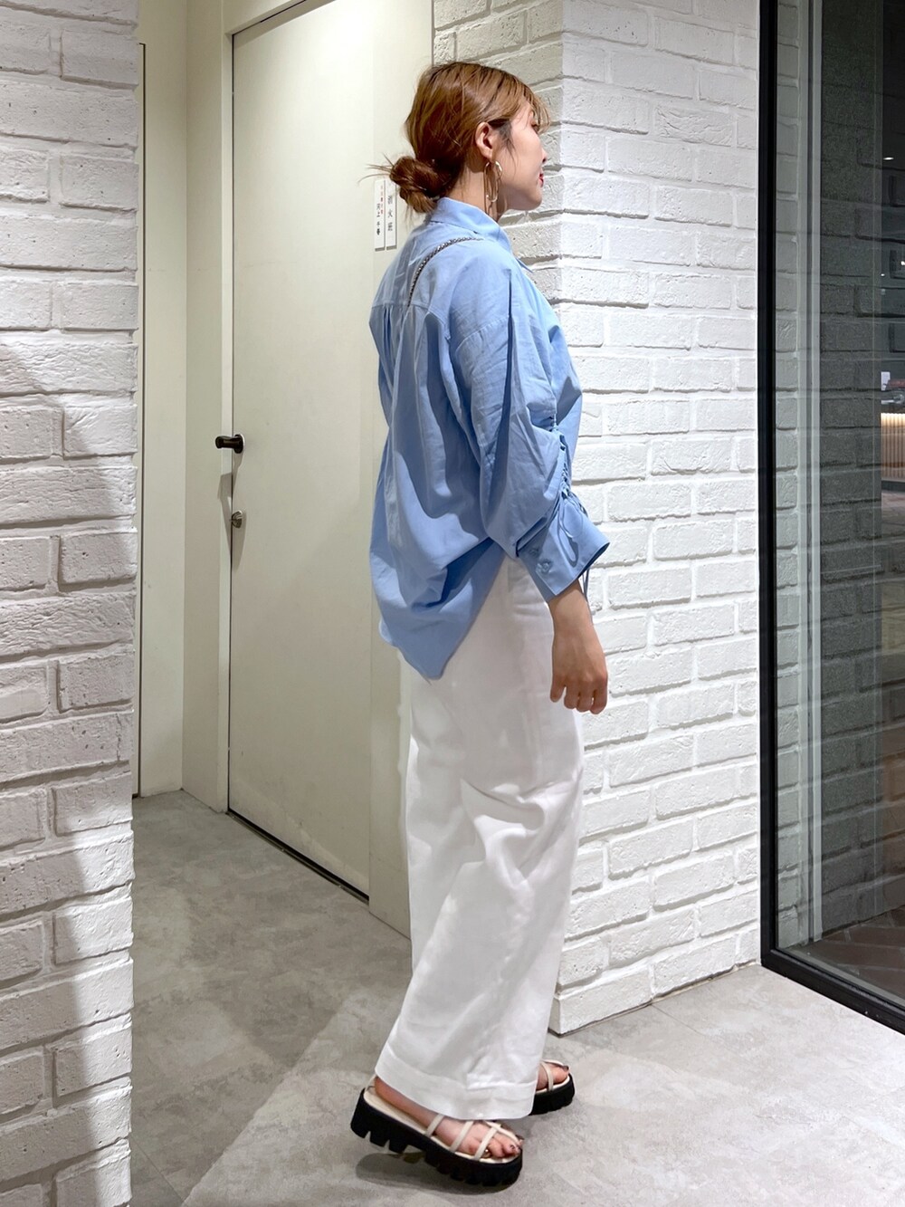 ブルー系のシャツ/ブラウス、ブラック系のショルダーバッグ、ホワイト系のデニムパンツを着用したレディースの夏コーディネートの6枚目の写真