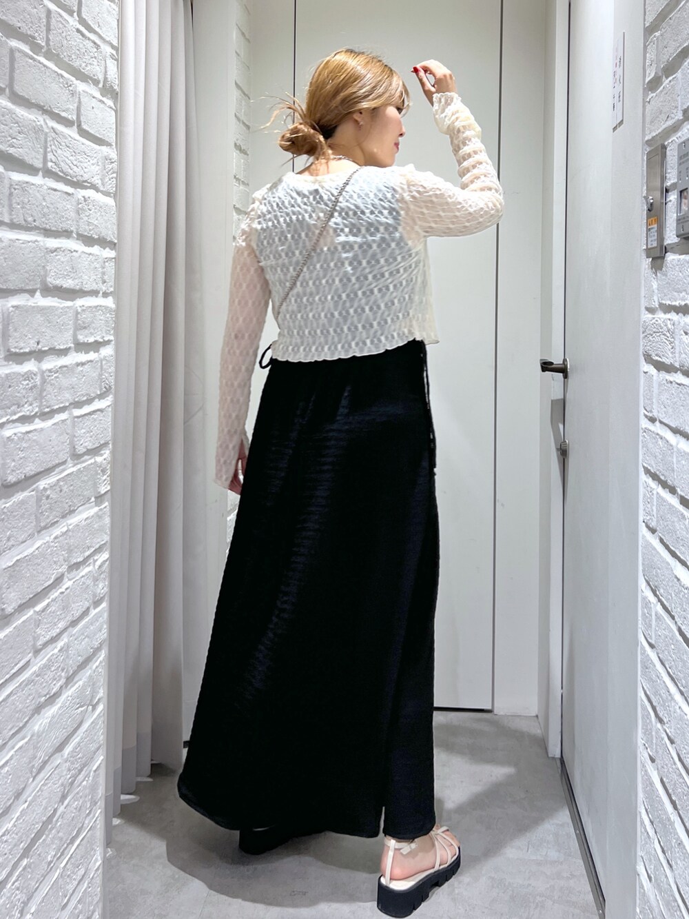 ブラック系のワンピース、ホワイト系のカーディガン/ボレロ、ホワイト系のサンダルを着用したレディースの夏コーディネートの3枚目の写真