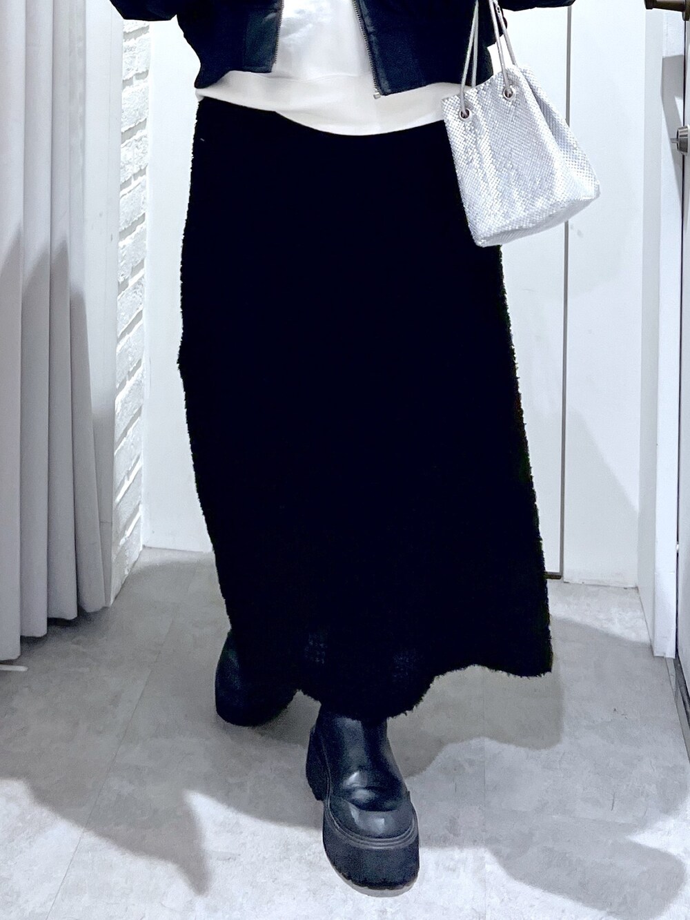 ブラック系のスカート、ホワイト系のスウェット、ブラック系のMA-1を着用したレディースの冬コーディネートの8枚目の写真