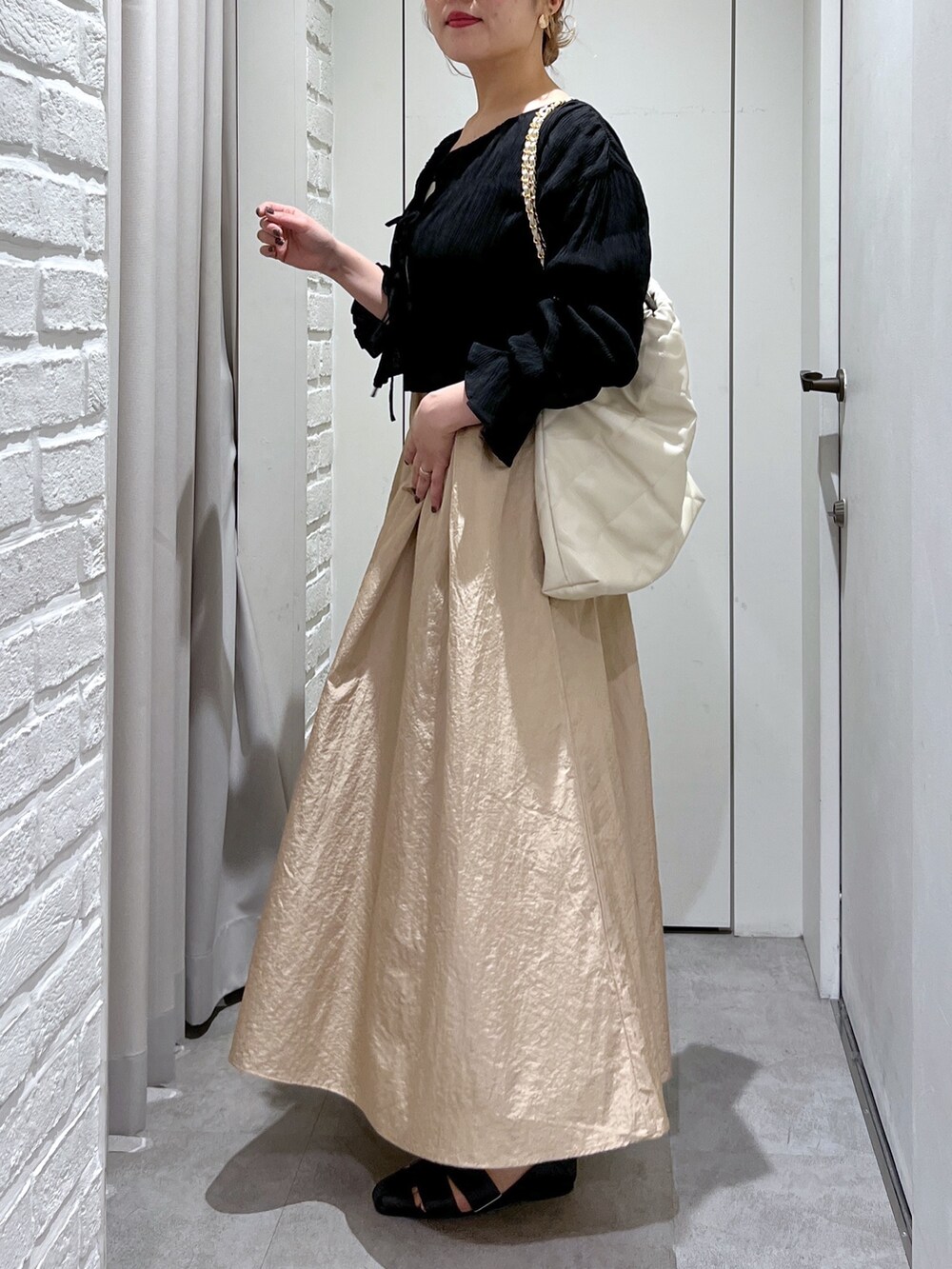 ベージュ系のワンピース、ブラック系のシャツ/ブラウス、ホワイト系のキャミソールを着用したレディースの春コーディネートの6枚目の写真