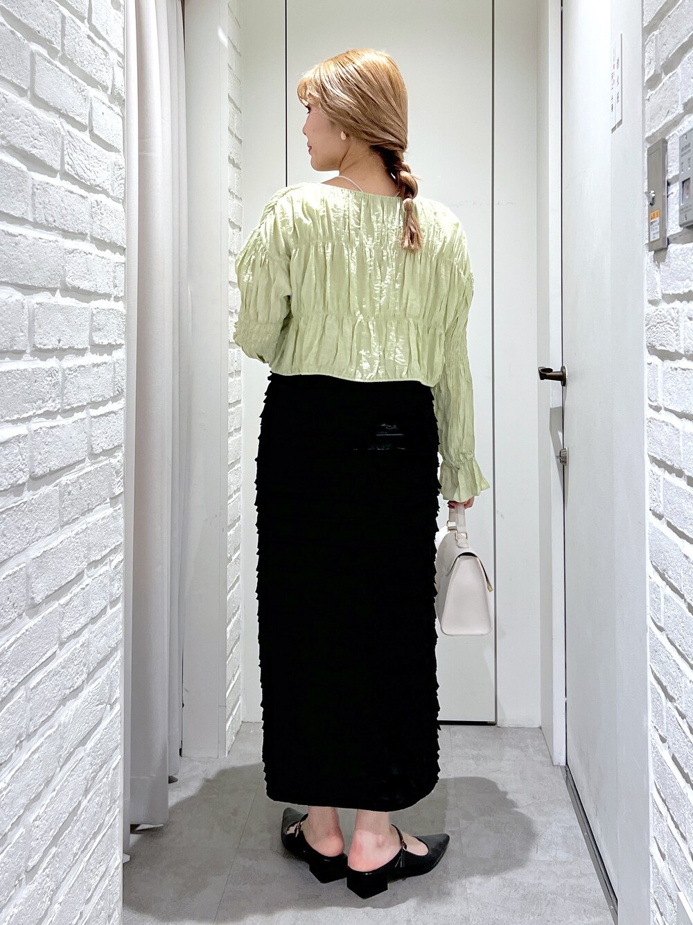 ブラック系のスカート、グリーン系のシャツ/ブラウス、ホワイト系のショルダーバッグを着用したレディースの春コーディネートの4枚目の写真