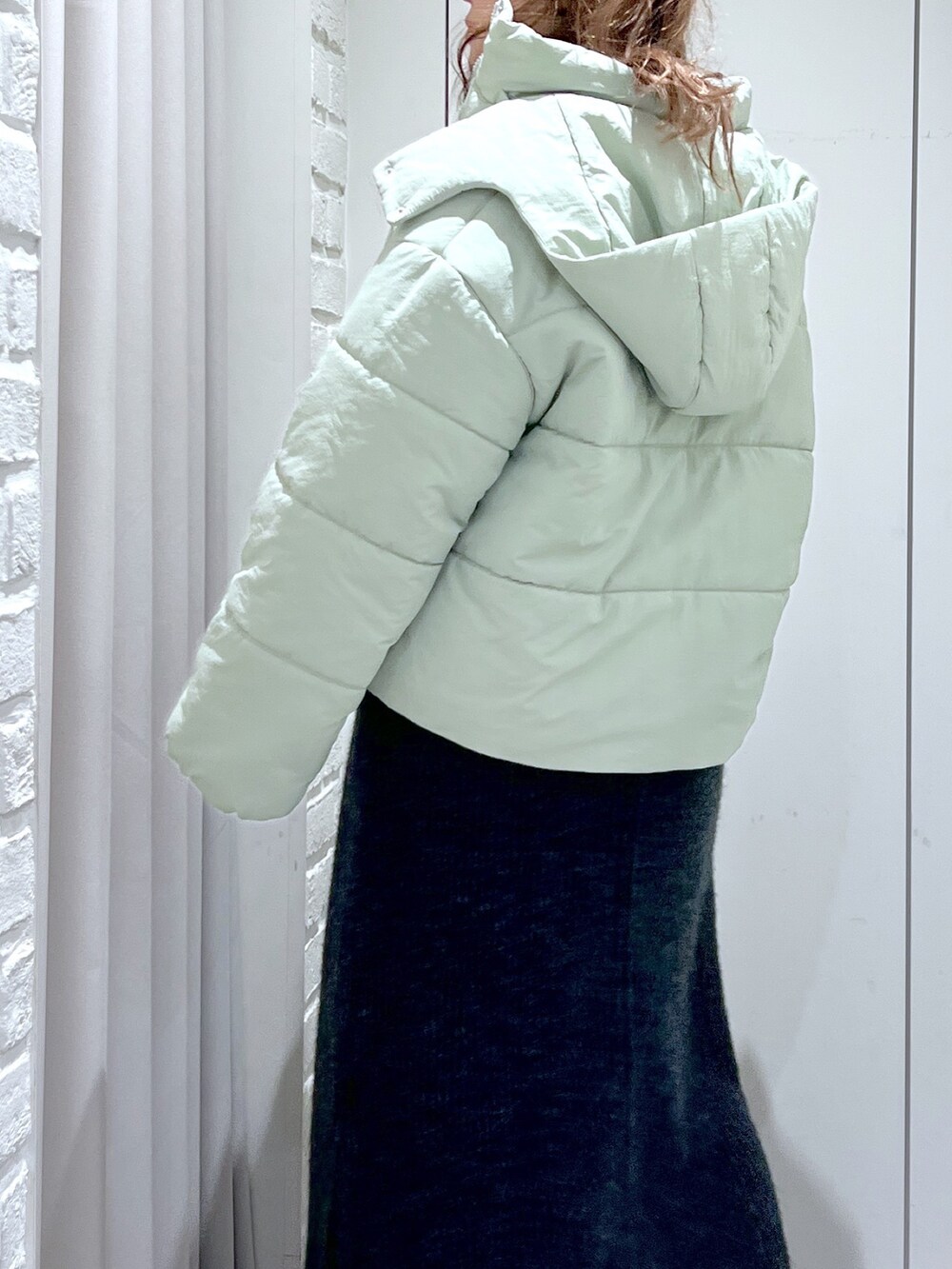 ブラック系のワンピース、グリーン系のブルゾン、ブラック系のショルダーバッグを着用したレディースの冬コーディネートの6枚目の写真