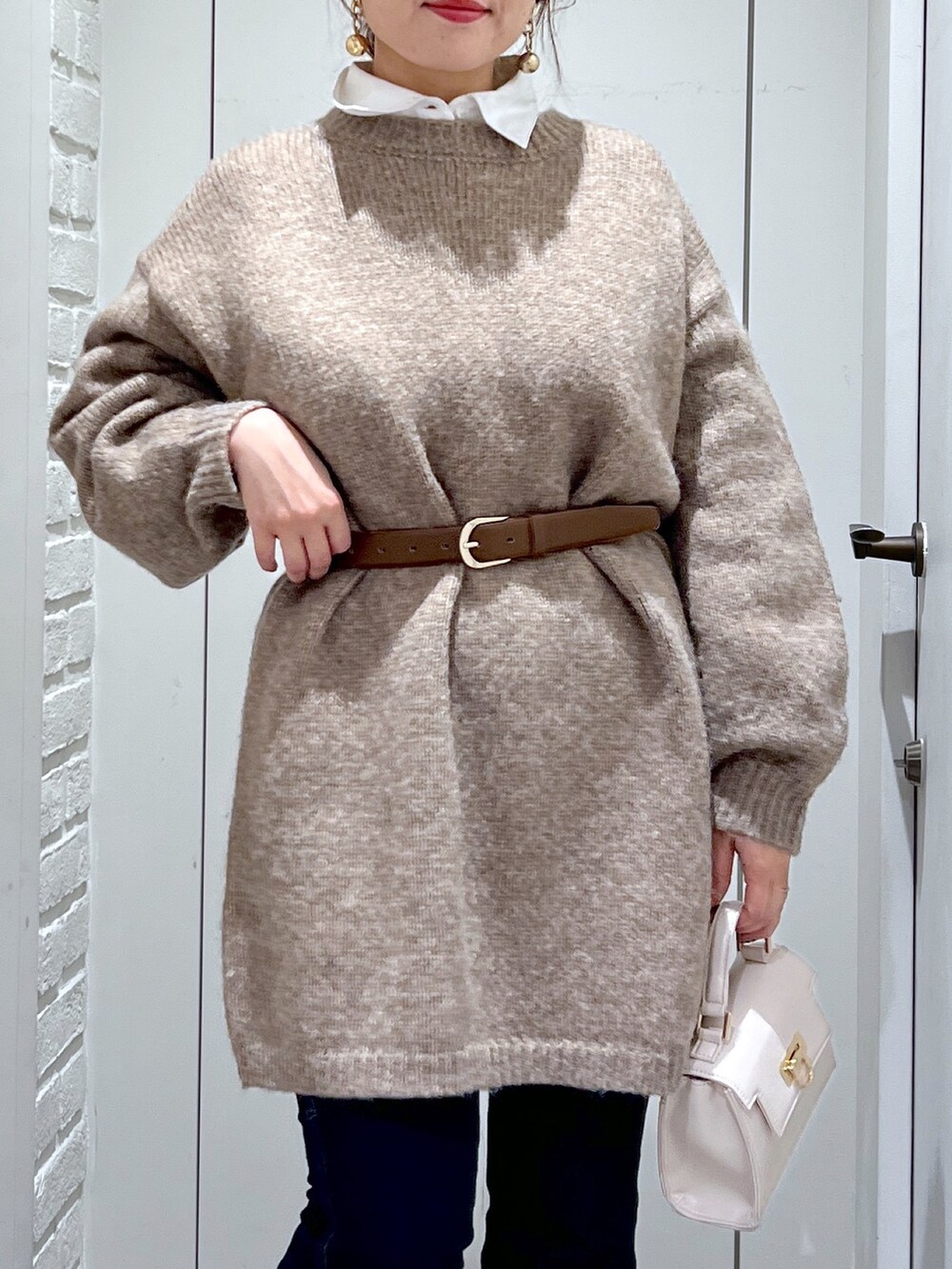 ブラウン系のワンピース、ホワイト系のショルダーバッグ、ブラック系のローファーを着用したレディースの冬コーディネートの5枚目の写真