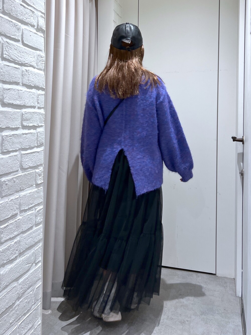 ブルー系のニット/セーター、ブラック系のショルダーバッグ、ブラック系のスカートを着用したレディースの秋コーディネートの2枚目の写真
