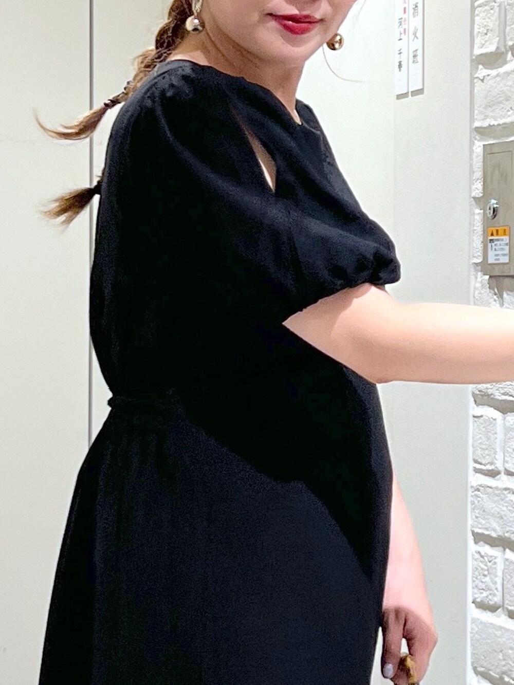 ホワイト系のショルダーバッグ、ブラック系のワンピース、イエロー系のサンダルを着用したレディースの夏コーディネートの7枚目の写真