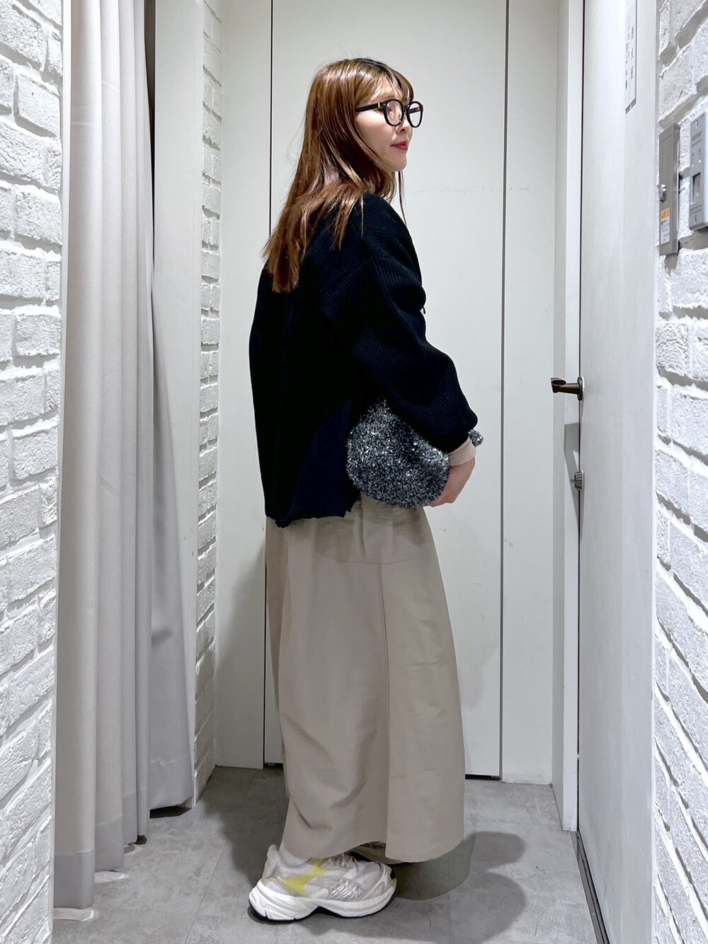 ベージュ系のワンピース、ブラック系のトートバッグ、ブラック系のカーディガン/ボレロを着用したレディースの冬コーディネートの2枚目の写真