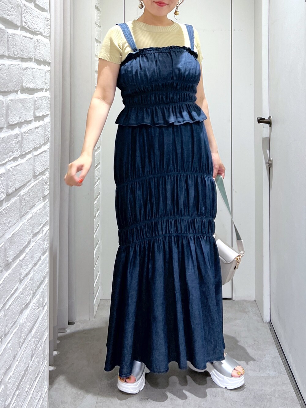 ブルー系のワンピース、イエロー系のニット/セーター、シルバー系のサンダルを着用したレディースの夏コーディネートの4枚目の写真