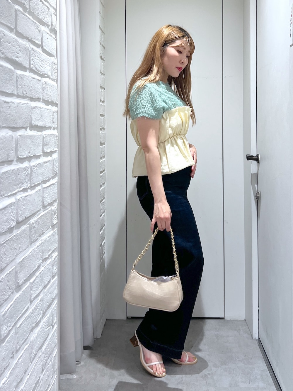 ブルー系のデニムパンツ、ベージュ系のトートバッグ、ホワイト系のシャツ/ブラウスを着用したレディースの夏コーディネートの3枚目の写真