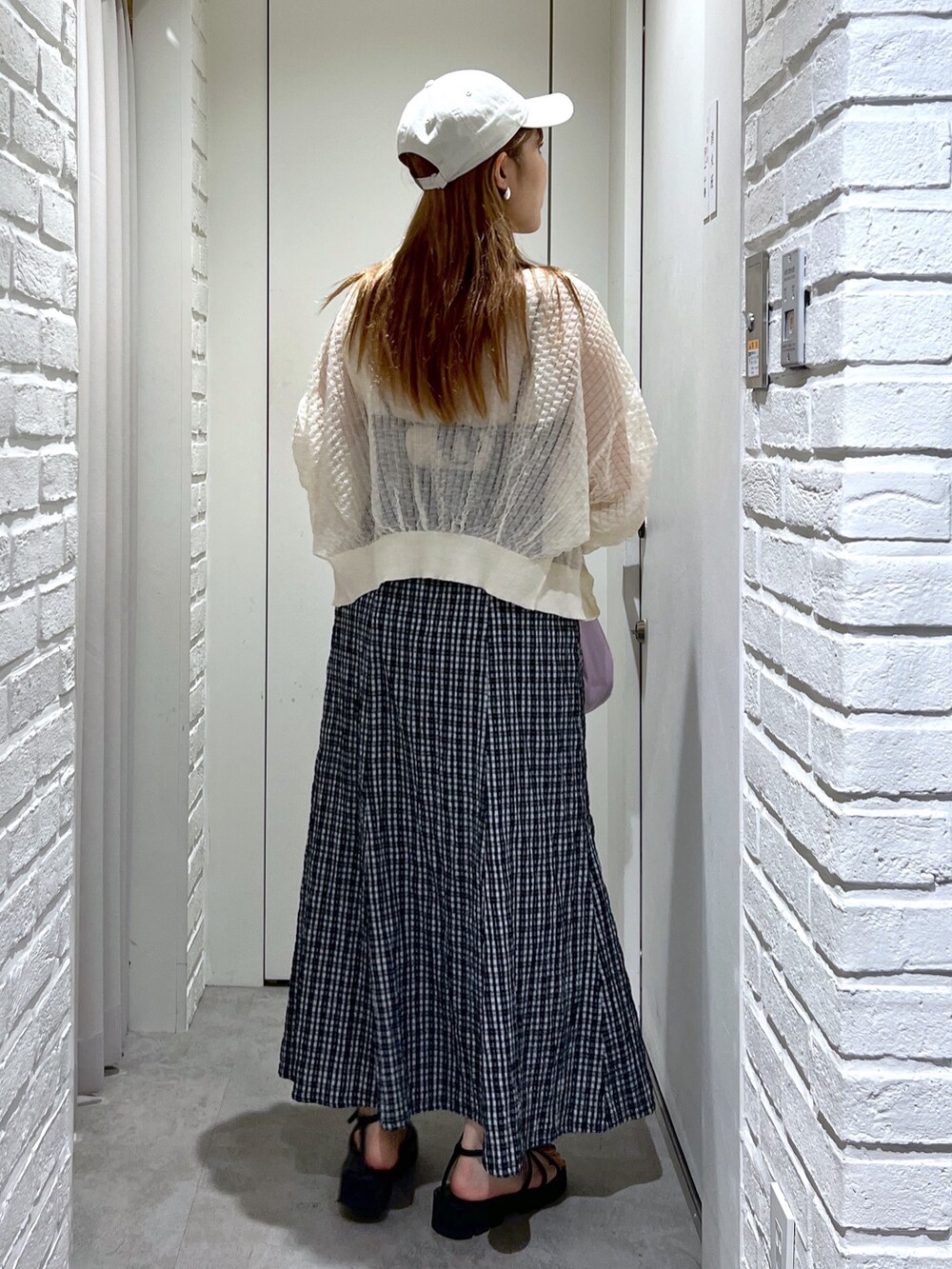 パープル系のハンドバッグ、ブラック系のサンダル、ホワイト系のカーディガン/ボレロを着用したレディースの夏コーディネートの4枚目の写真