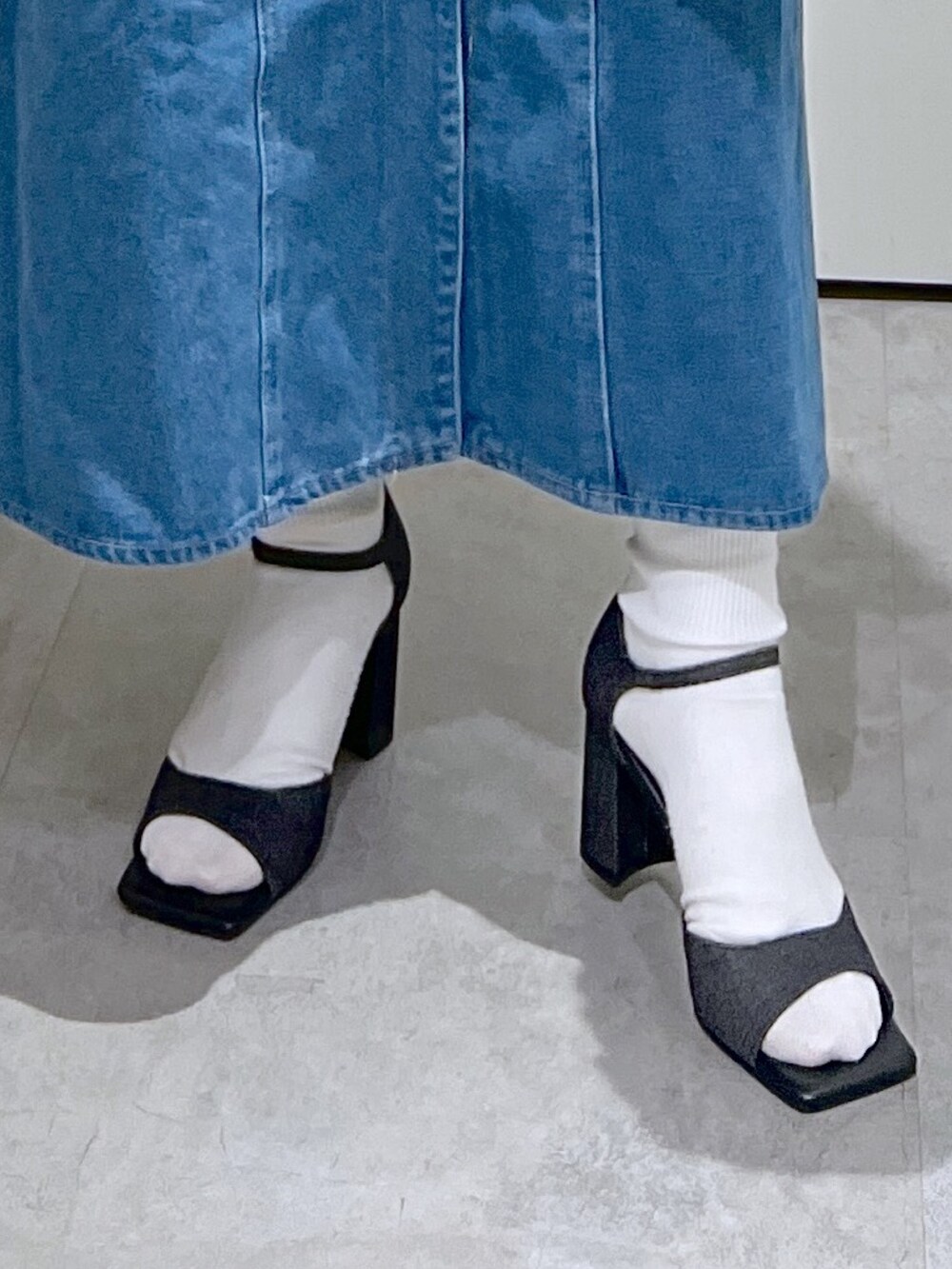 ブルー系のワンピース、ブラック系のサンダル、ブラック系のハンドバッグを着用したレディースの春コーディネートの7枚目の写真