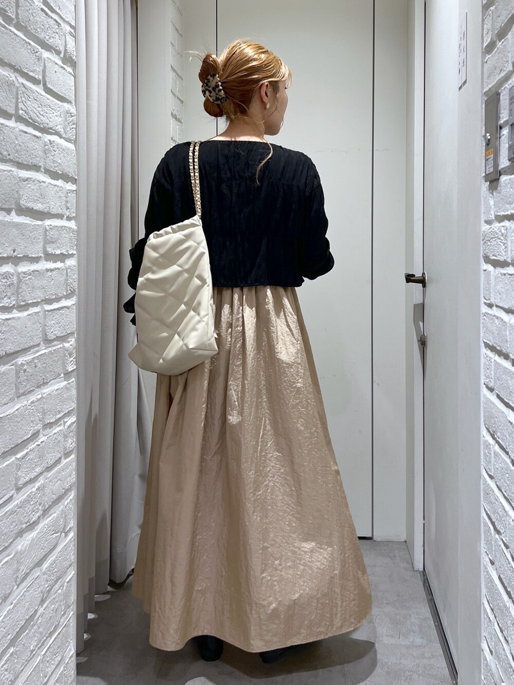 ベージュ系のワンピース、ブラック系のシャツ/ブラウス、ホワイト系のキャミソールを着用したレディースの春コーディネートの3枚目の写真