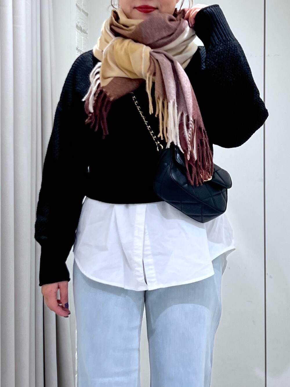 ブルー系のデニムパンツ、ブラック系のショルダーバッグ、ブラック系のニット/セーターを着用したレディースの冬コーディネートの7枚目の写真