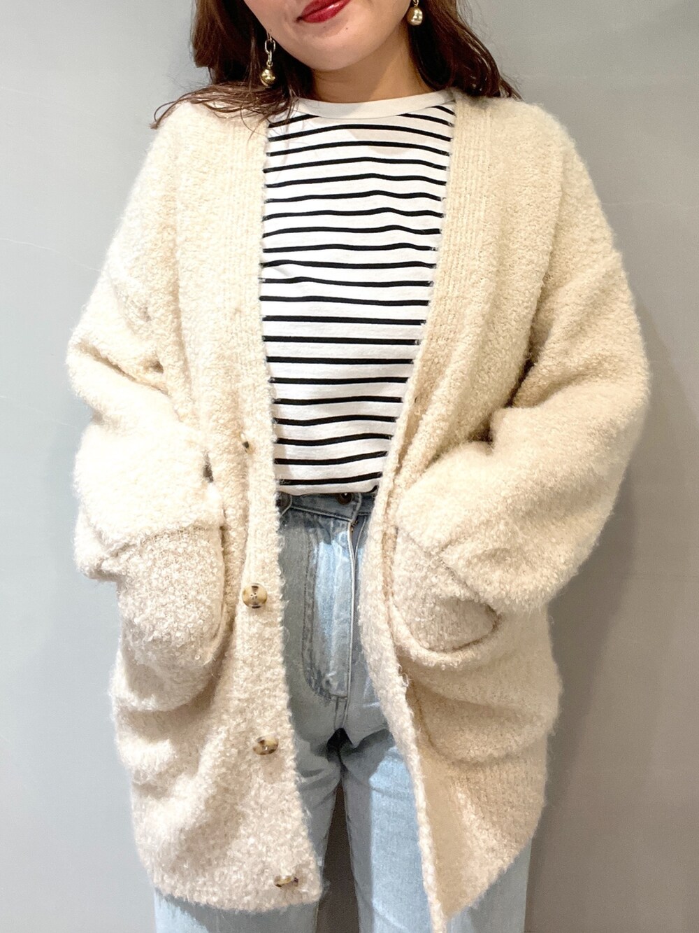 オレンジ系のショルダーバッグ、ブラック系のTシャツ/カットソー、ホワイト系のカーディガン/ボレロを着用したレディースの秋コーディネートの4枚目の写真