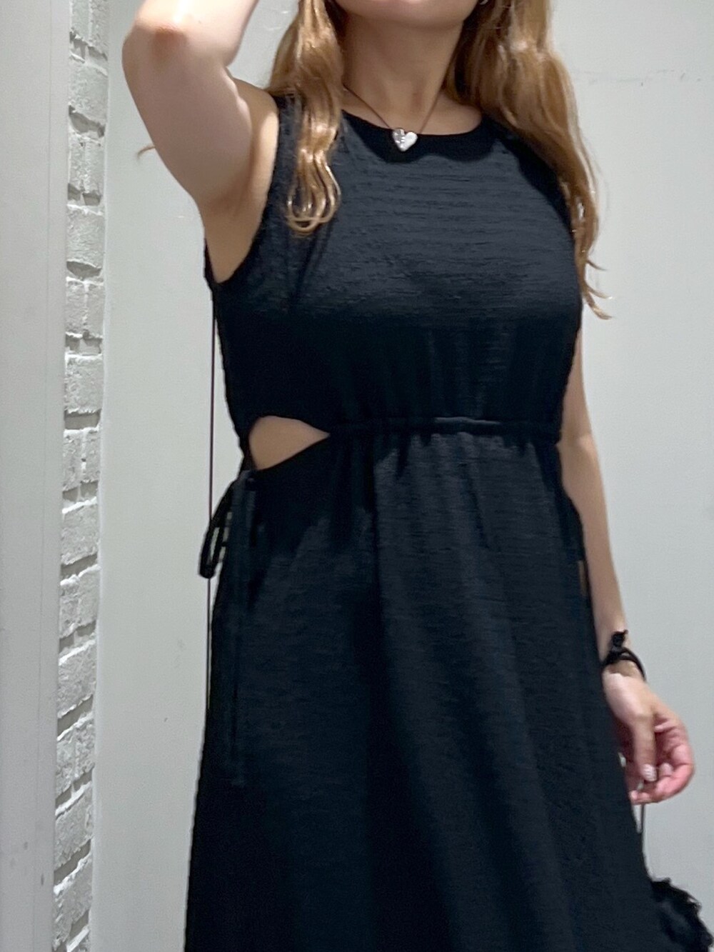 ブラック系のワンピース、ブラック系のハンドバッグ、ホワイト系のサンダルを着用したレディースの夏コーディネートの9枚目の写真