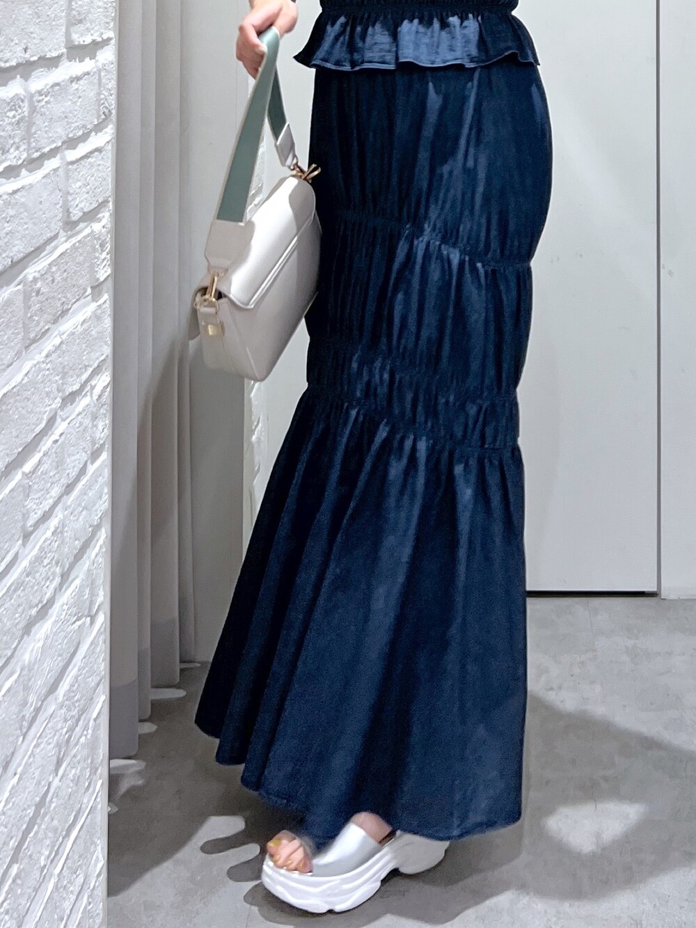 ブルー系のワンピース、イエロー系のニット/セーター、シルバー系のサンダルを着用したレディースの夏コーディネートの6枚目の写真