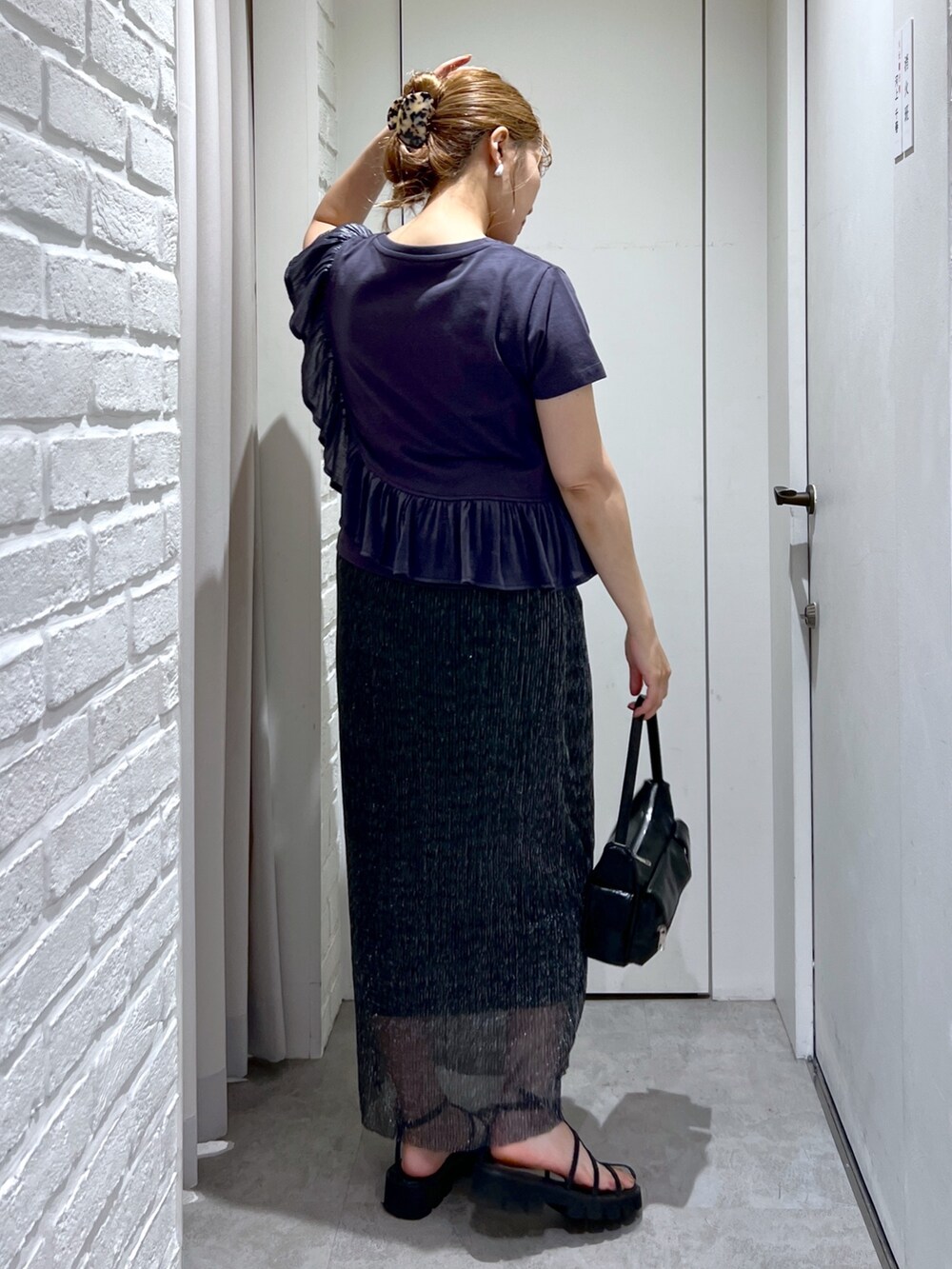 ブラック系のスカート、グレー系のTシャツ/カットソー、ブラック系のサンダルを着用したレディースの夏コーディネートの8枚目の写真