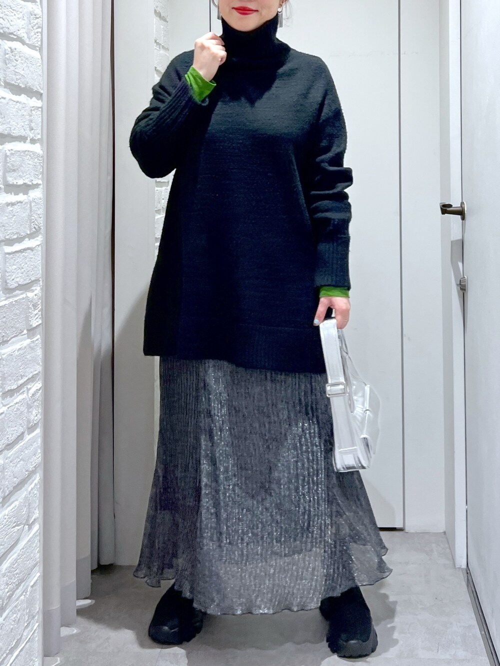 ブラック系のニット/セーター、ブラック系のスカート、ブラック系のブーツを着用したレディースの冬コーディネートの4枚目の写真