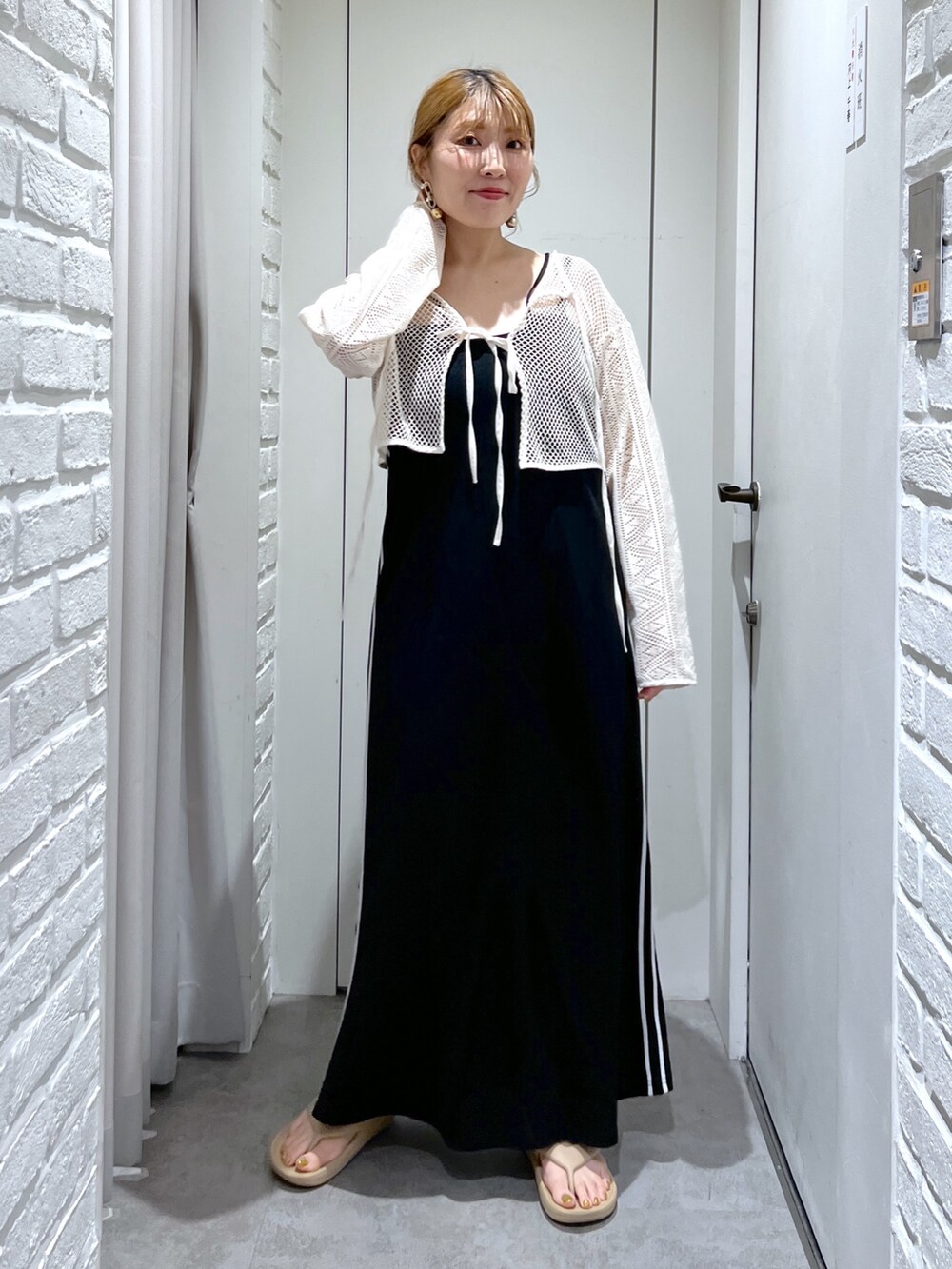 ブラック系のワンピース、ホワイト系のカーディガン/ボレロ、ブラック系のトートバッグを着用したレディースの夏コーディネートの7枚目の写真