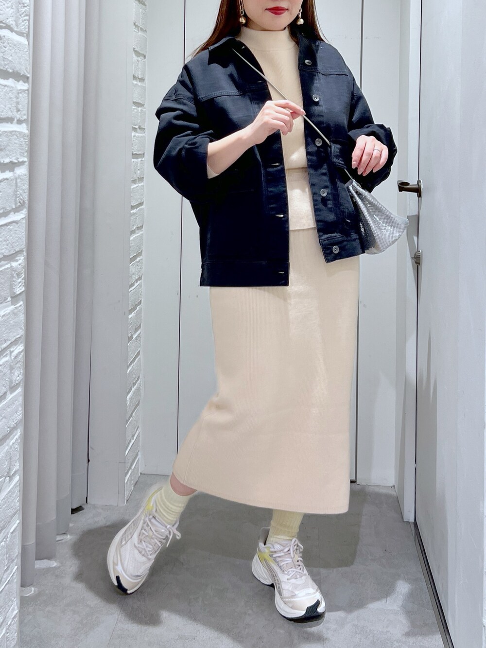 ホワイト系のワンピース、シルバー系のショルダーバッグ、ブラック系のデニムジャケットを着用したレディースの冬コーディネートの6枚目の写真