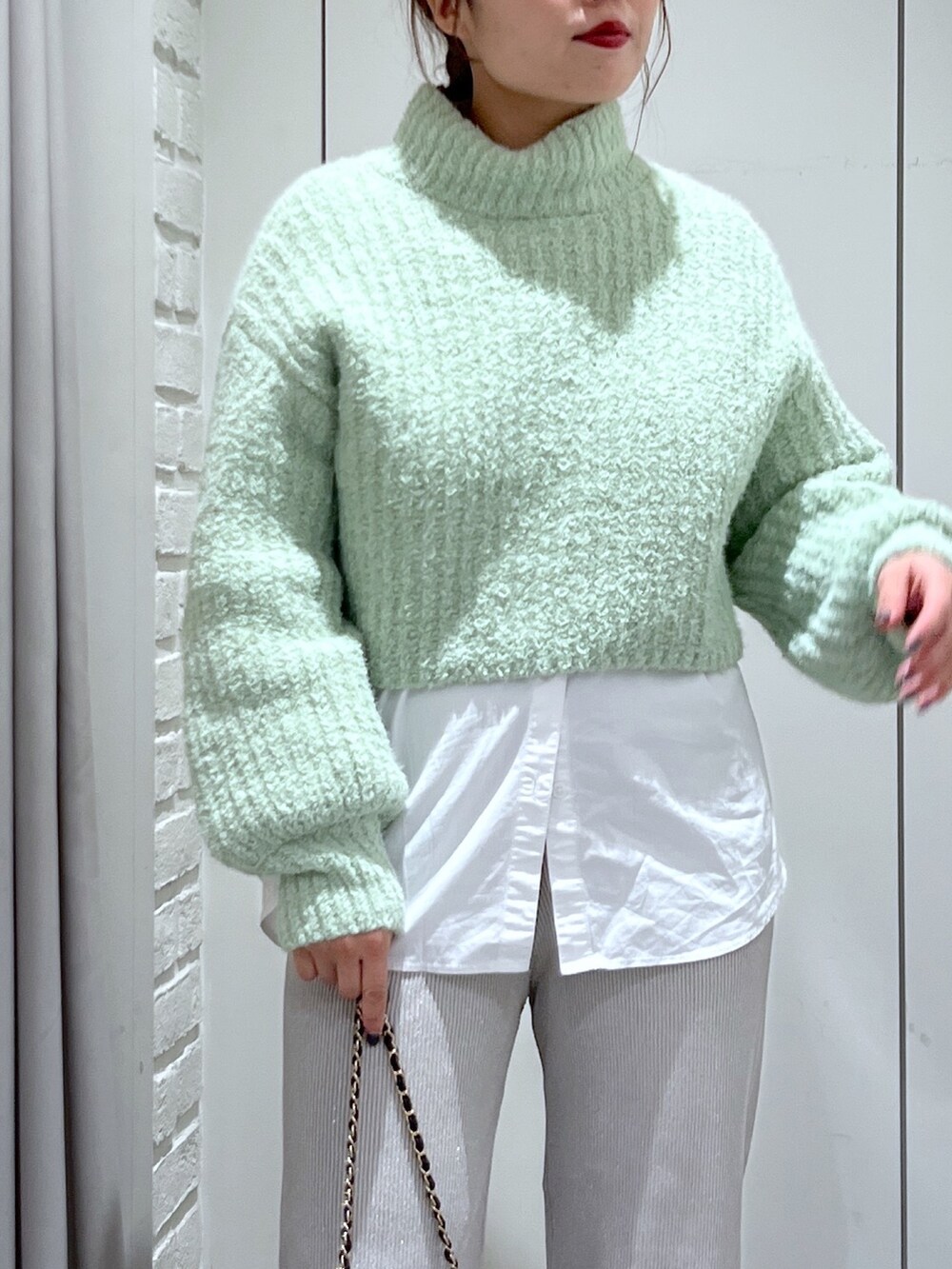 ホワイト系のシャツ/ブラウス、ホワイト系のその他パンツ、グリーン系のニット/セーターを着用したレディースの冬コーディネートの5枚目の写真