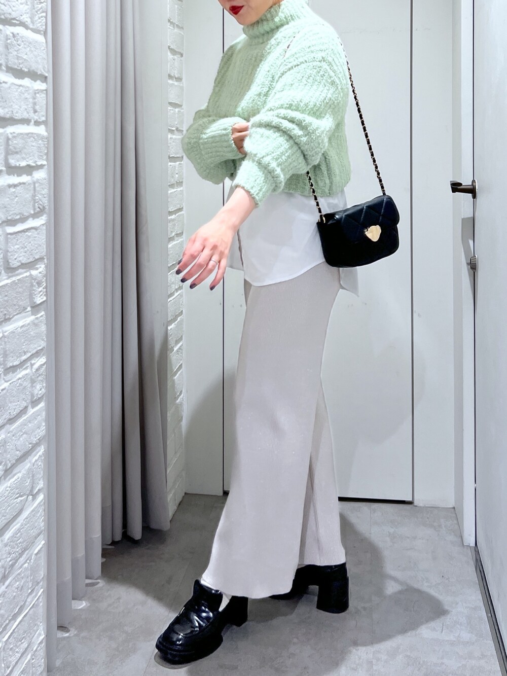 ホワイト系のシャツ/ブラウス、ホワイト系のその他パンツ、グリーン系のニット/セーターを着用したレディースの冬コーディネートの6枚目の写真