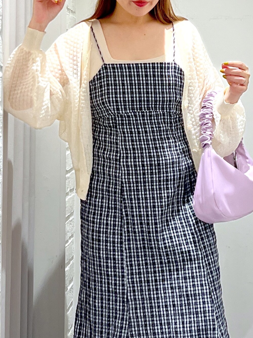 パープル系のハンドバッグ、ブラック系のサンダル、ホワイト系のカーディガン/ボレロを着用したレディースの夏コーディネートの9枚目の写真