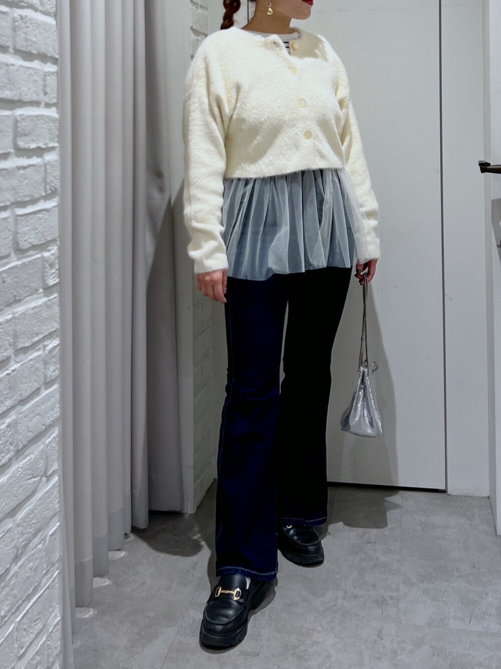 ホワイト系のシャツ/ブラウス、ホワイト系のカーディガン/ボレロ、ブルー系のデニムパンツを着用したレディースの冬コーディネートの2枚目の写真