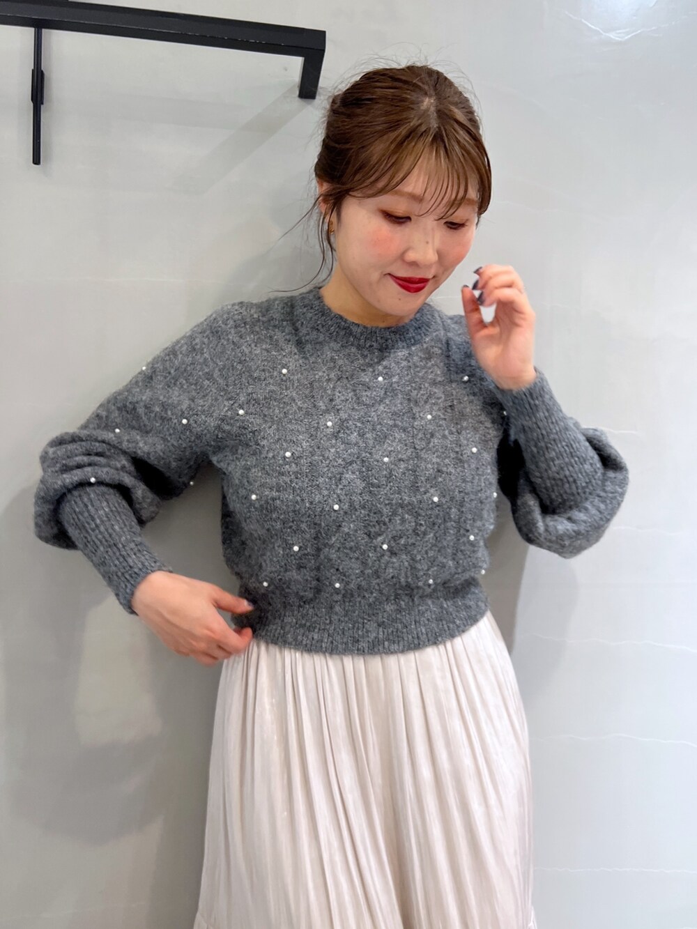 ホワイト系のスカート、グレー系のニット/セーター、ブラック系のショルダーバッグを着用したレディースの冬コーディネートの6枚目の写真