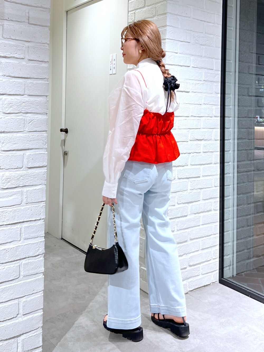 ブルー系のデニムパンツ、ブラック系のサンダル、レッド系のシャツ/ブラウスを着用したレディースの夏コーディネートの3枚目の写真