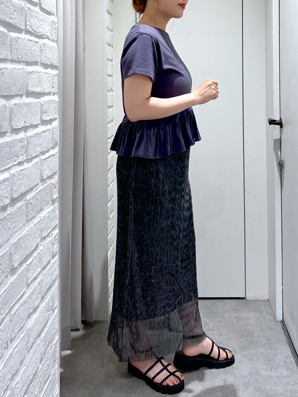 ブラック系のスカート、グレー系のTシャツ/カットソー、ブラック系のサンダルを着用したレディースの夏コーディネートの7枚目の写真