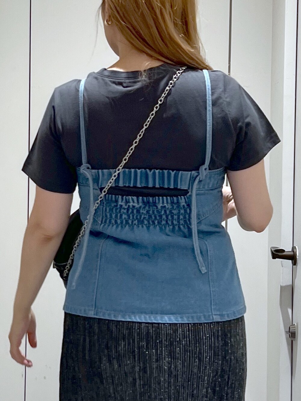 ブラック系のスカート、ブルー系のベスト、ブラック系のショルダーバッグを着用したレディースの夏コーディネートの8枚目の写真