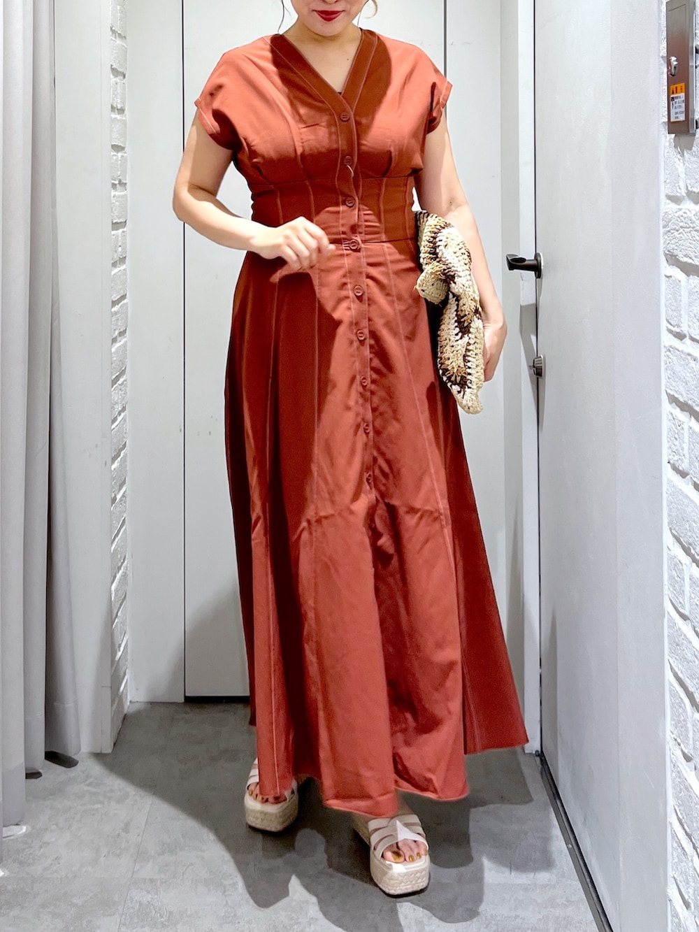 ブラウン系のワンピース、ベージュ系のトートバッグ、ホワイト系のサンダルを着用したレディースの夏コーディネートの5枚目の写真