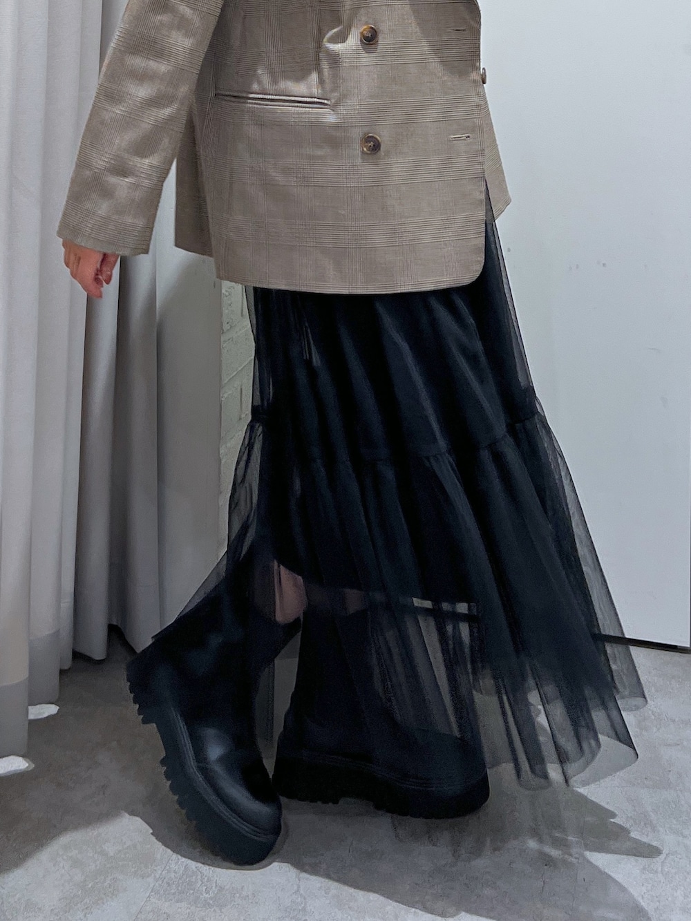 ブラウン系のテーラードジャケット、ホワイト系のニット/セーター、ブラック系のスカートを着用したレディースの秋コーディネートの5枚目の写真