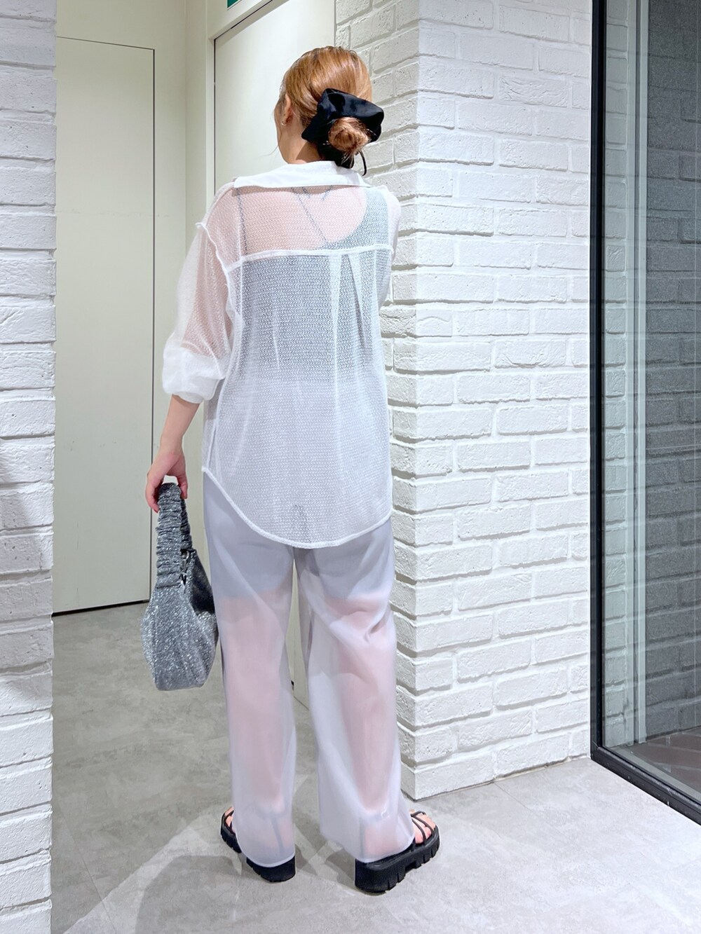 ホワイト系のシャツ/ブラウス、グレー系のその他パンツ、ブラック系のサンダルを着用したレディースの夏コーディネートの2枚目の写真