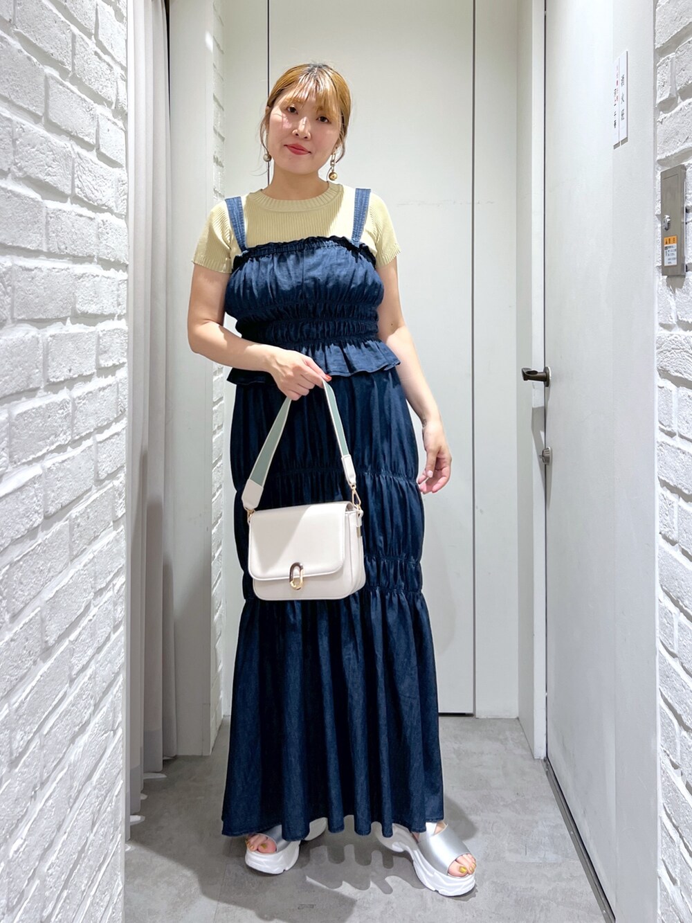 ブルー系のワンピース、イエロー系のニット/セーター、シルバー系のサンダルを着用したレディースの夏コーディネートの7枚目の写真