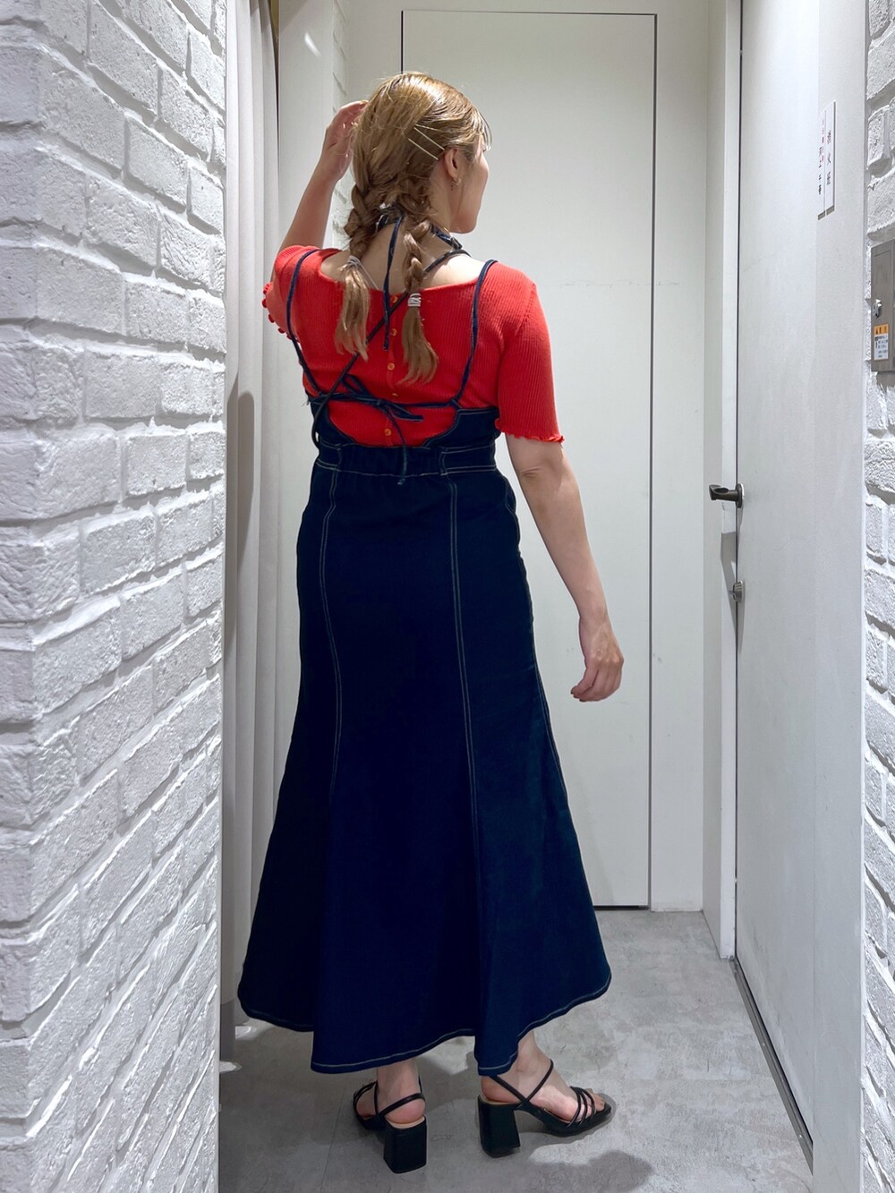 ブラック系のハンドバッグ、ブルー系のワンピース、レッド系のニット/セーターを着用したレディースの夏コーディネートの3枚目の写真