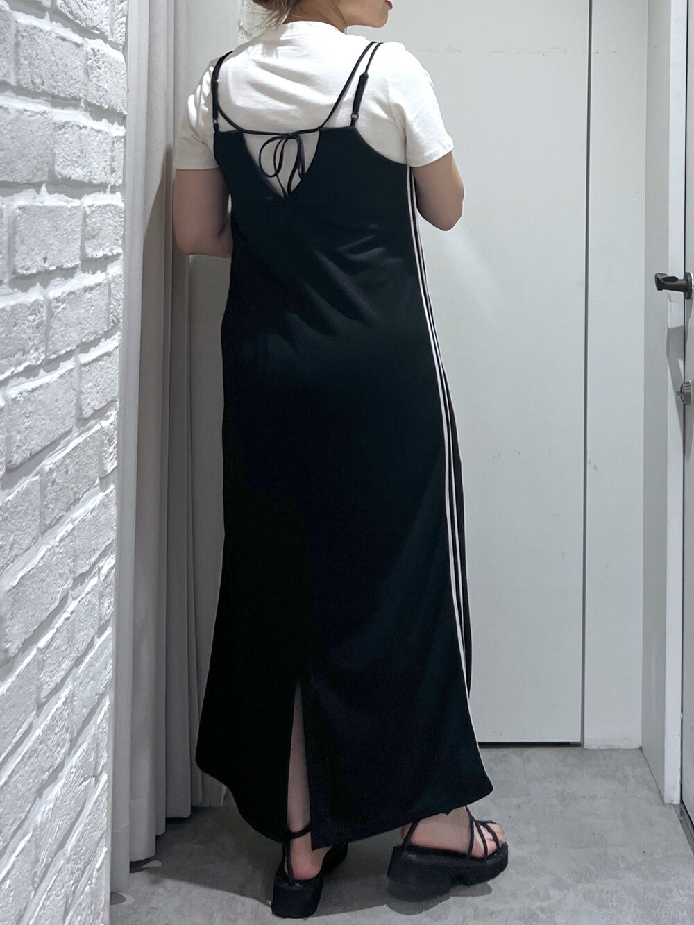 ブラック系のワンピース、ホワイト系のTシャツ/カットソー、ブラック系のサンダルを着用したレディースの夏コーディネートの5枚目の写真