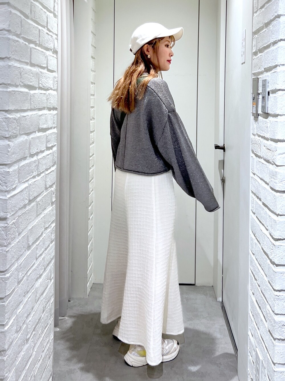 ホワイト系のワンピース、ブラック系のボディバッグ/ウエストポーチ、シルバー系のニット/セーターを着用したレディースの春コーディネートの4枚目の写真